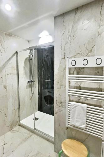 une salle de bain avec une douche avec une porte vitrée dans l'établissement Château Versailles, logement Neuf, à Versailles