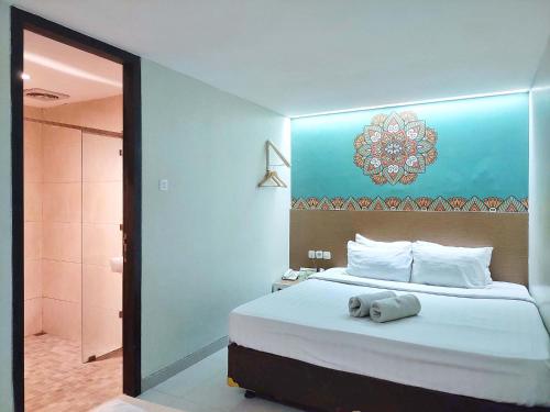 a bedroom with a large bed and a bathroom at Shinta Guesthouse in Malang