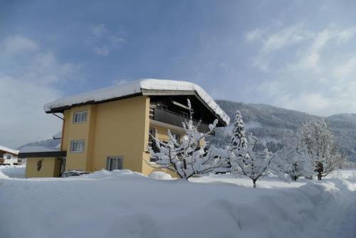 a building covered in snow with snow covered trees at Haus Sonne in Kirchdorf in Tirol