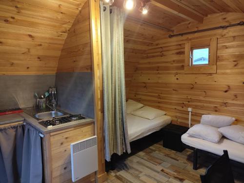 a small kitchen in a log cabin with a sink at Camping de la Vallée du Doux in Boucieu-Le-Roi