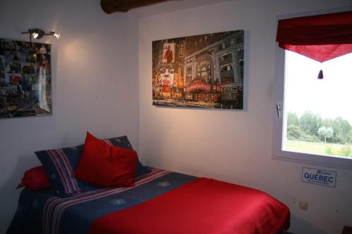 une chambre avec un lit avec des oreillers rouges et une fenêtre dans l'établissement Grand Mas en Provence avec piscine, à Istres