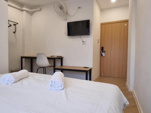 a bedroom with a bed and a desk and a television at Lunar Hostel in Vientiane