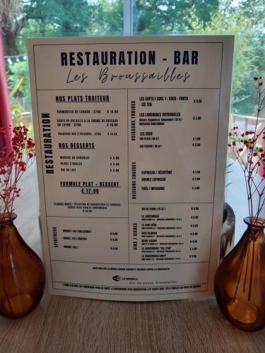 a menu for a restaurant with two vases at Motel Les Broussailles in Mesves-sur-Loire