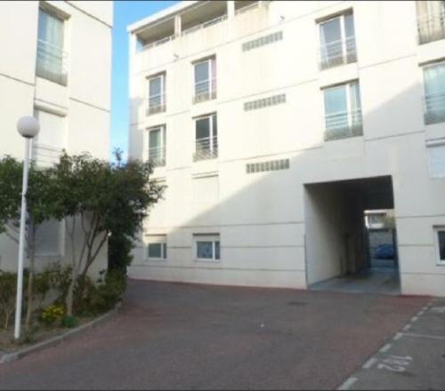 un grand bâtiment blanc avec un grand garage dans l'établissement Appartement accès direct rempart, à Avignon