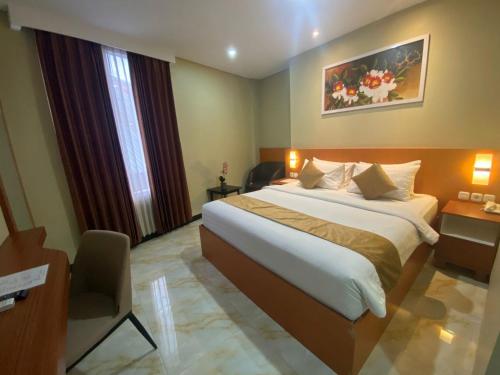 a bedroom with a large bed in a hotel room at Grand Avira Hotel in Batu Merah