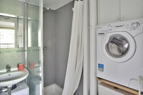 une salle de bain avec une machine à laver et un lavabo dans l'établissement Charmant studio, central, à Paris