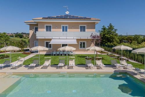 a villa with a swimming pool in front of a house at Villa Lina in Morrovalle