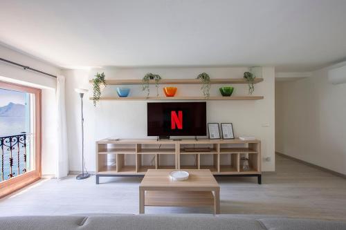 a living room with a tv with the letter n on it at La Sentinella - Lake View & Panoramic Terrace in Valsolda
