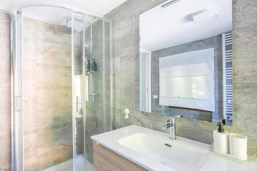 a bathroom with a sink and a shower at La Sentinella - Lake View & Panoramic Terrace in Valsolda