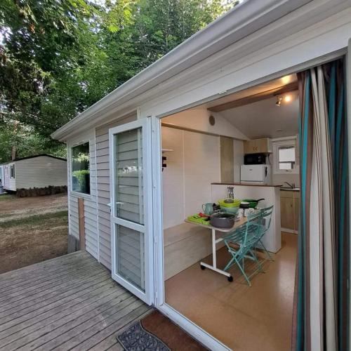une grande porte coulissante en verre menant à une cuisine avec une table dans l'établissement Camping de la Vallée du Doux, à Boucieu-Le-Roi