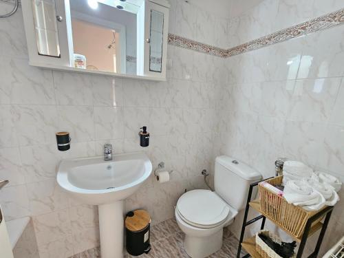 a white bathroom with a toilet and a sink at Sylvia's Sweet Home in Kato Korakiana