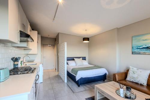 a small room with a bed and a kitchen at Stylish Table View Studio Fully Equipped in Cape Town