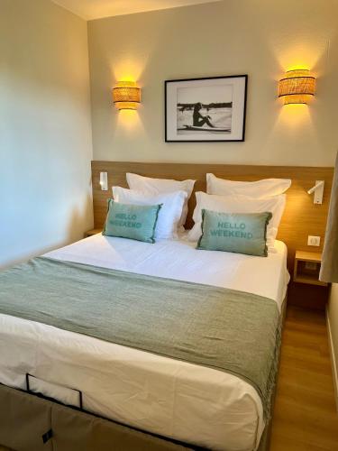 une chambre avec un grand lit avec deux oreillers dans l'établissement L Olivier de la Palmeraie, à Grimaud