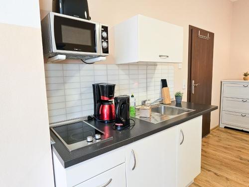 a kitchen counter with a coffee maker and a microwave at Villa Utpatel Whg 02 in Ahlbeck