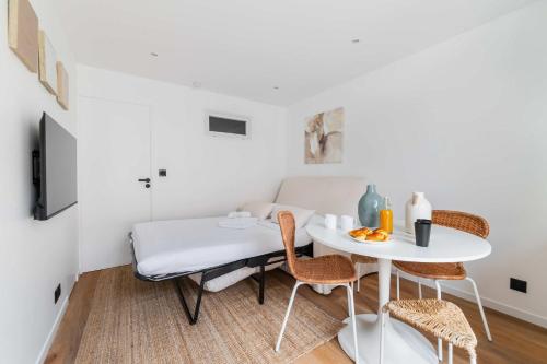 a room with a bed and a table with chairs at Escapade urbaine Appartement Mairie des lilas in Les Lilas