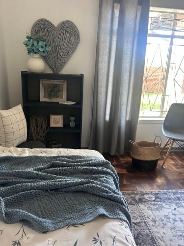 a bedroom with a bed with a blue blanket on it at Lielies Guesthouse in Parys