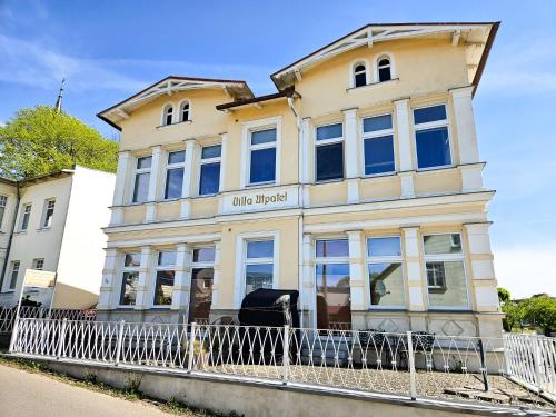 a white building with a fence in front of it at Villa Utpatel Whg 03 in Ahlbeck