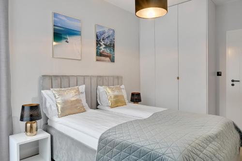 a bedroom with two beds with white walls at Scala City Center Premium Apartments with Parking by Lion Apartments in Gdańsk