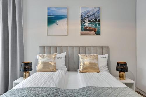 a bedroom with two beds and three pictures on the wall at Scala City Center Premium Apartments with Parking by Lion Apartments in Gdańsk