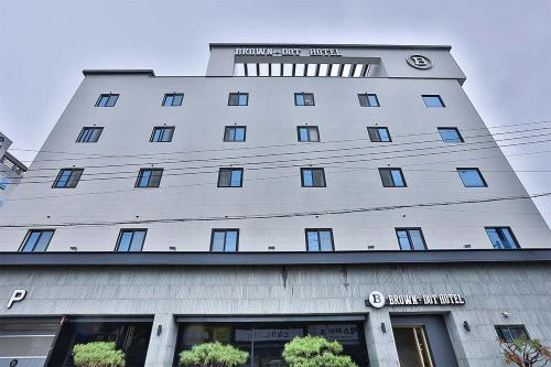 a large white building with a clock on it at Brown Dot Gumi Okgye in Gumi