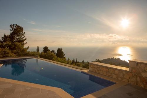 a swimming pool with a view of the ocean at Emilia Villas in Agios Nikitas