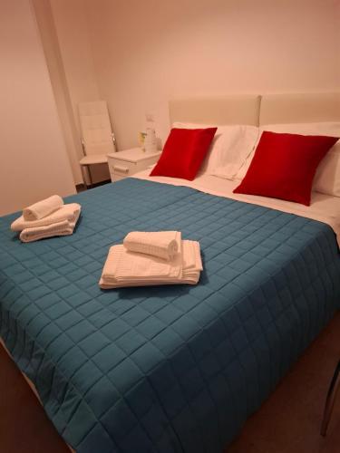 a large blue bed with red pillows and towels on it at Dimora Kalypso in Polignano a Mare