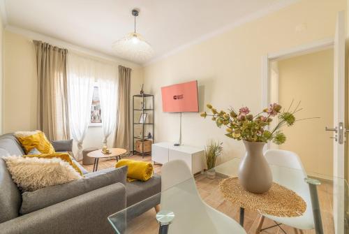 a living room with a couch and a vase of flowers at GuestReady – Quiet Escape in Setúbal in Setúbal