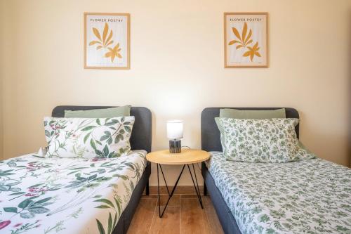 two beds sitting next to each other in a room at GuestReady – Quiet Escape in Setúbal in Setúbal
