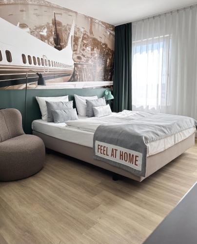 a bedroom with a large bed with a sign that reads feel at home at Coffee Fellows Hotel Frankfurt Airport-Langen in Langen