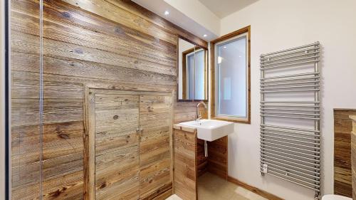La salle de bains est pourvue d'un mur en bois. dans l'établissement SOLARIUM SR27 COSY & VIEW 4 Pers, à Châtel