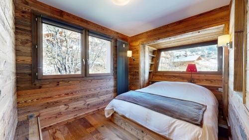 - une chambre avec des murs en bois et un lit dans une chambre avec des fenêtres dans l'établissement SOLARIUM SR27 COSY & VIEW 4 Pers, à Châtel