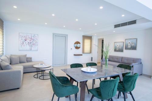 a living room with a table and green chairs at Emilia Villas in Agios Nikitas