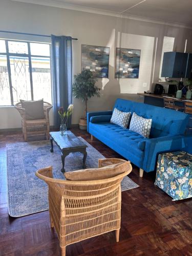 a living room with a blue couch and a table at Lilibeth guesthouse in Parys