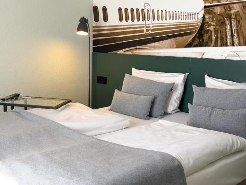 a bedroom with two beds and a boat on the wall at Coffee Fellows Hotel Frankfurt Airport-Langen in Langen