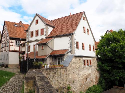 a white house with a stone wall at Die alte Kantorei - historische Ferienwohnung in Kahla