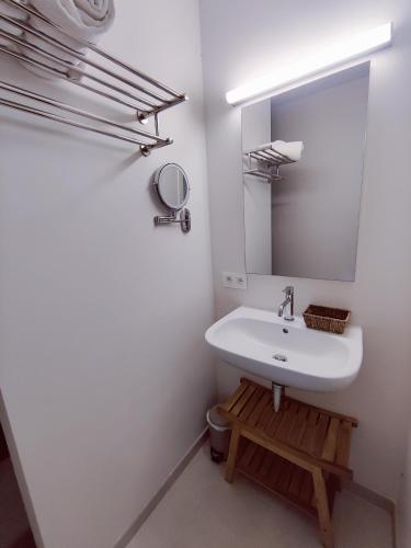 a white bathroom with a sink and a mirror at Het Weiland Villa Jersey in Damme