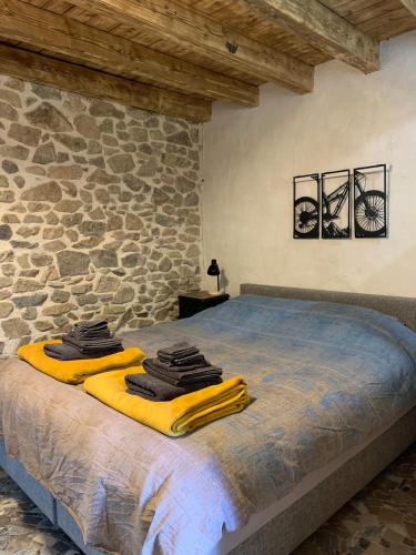une chambre avec un lit avec un mur en pierre dans l'établissement Gîte MTB Morvan voor fiets en natuurliefhebbers, à Cussy-en-Morvan