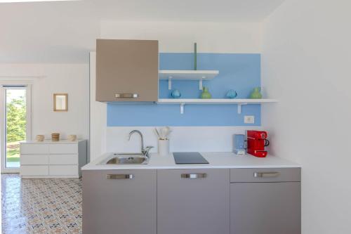 a kitchen with white cabinets and a red appliance at Villa Lina in Morrovalle