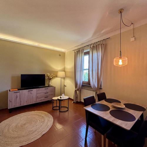 a living room with a table and a tv at Tenuta Lamborghini Golf & Resort in Panicale