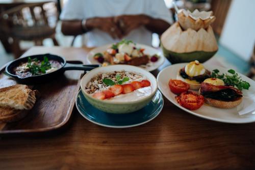 een tafel met een kom soep en borden eten bij Deep Roots Dive & Yoga Resort in Nusa Penida