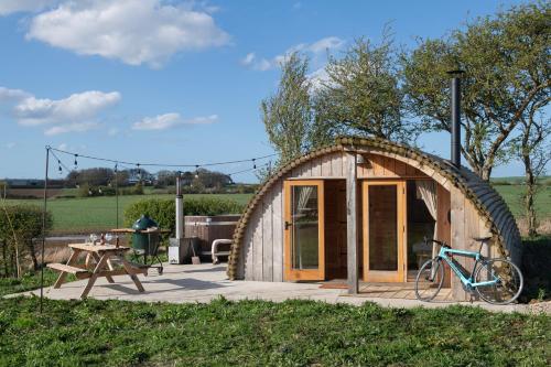 a small wooden shed with a bike parked outside at The Hygge Out - Glamping Site in North Yorkshire in Ebberston