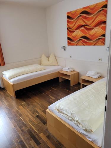 a room with two beds and a painting on the wall at Bildungshaus Schloss Retzhof in Wagna