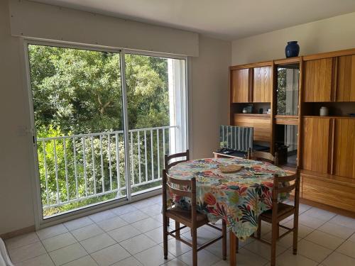 une salle à manger avec une table et une grande fenêtre dans l'établissement Appartement pereire plage a pied, à Arcachon