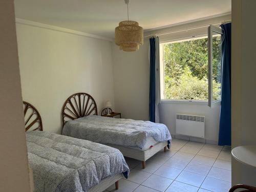 une chambre avec deux lits et une fenêtre dans l'établissement Appartement pereire plage a pied, à Arcachon