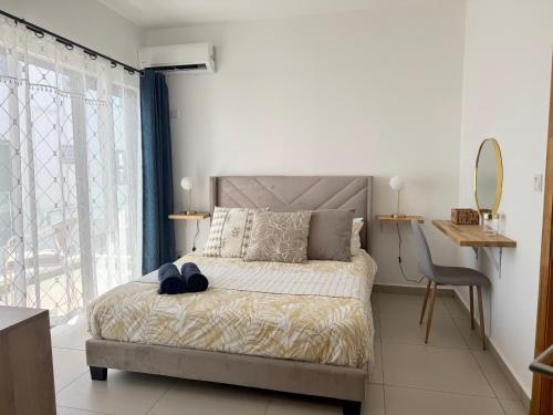 a bedroom with a bed with a mirror and a chair at Paddington House - private pool & rooftop in Flic-en-Flac