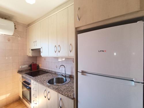 a kitchen with a white refrigerator and a sink at AyF ESPECTACULARES VISTAS DE MORRO DE GOS in Oropesa del Mar
