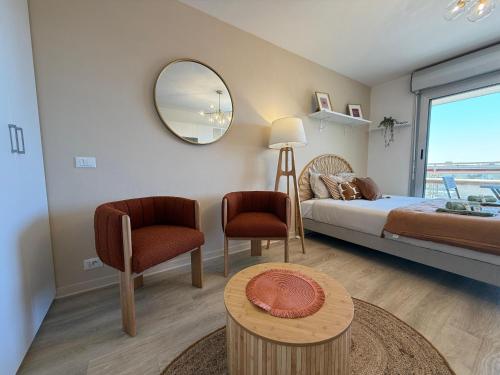 une chambre avec un lit, un miroir et une table dans l'établissement Le pano, à Beausoleil