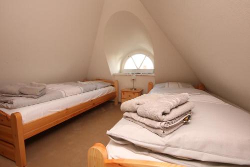 two beds in a attic with towels on them at Dat Lilli und Anni Huus in Böhl