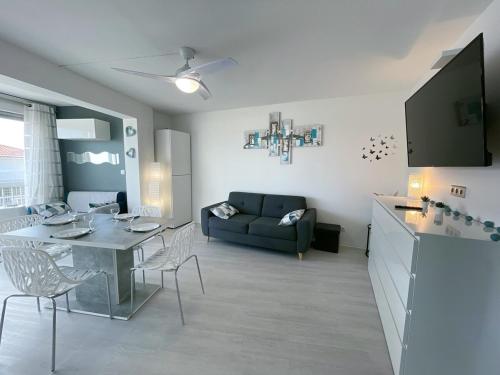 un salon avec une table et un canapé dans l'établissement évasion méditerranéenne - vue mer - plage, au Barcarès