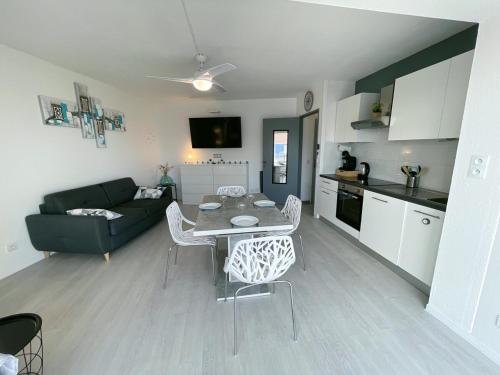 une cuisine et un salon avec une table et des chaises dans l'établissement évasion méditerranéenne - vue mer - plage, au Barcarès